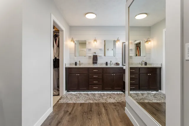 a spacious bathroom with a granite countertop sink shower and a mirror