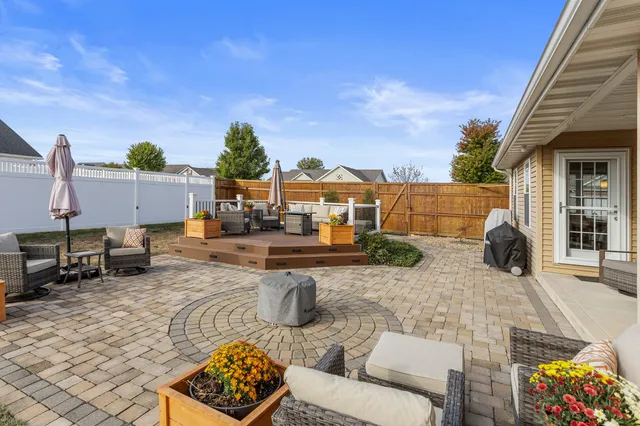 a view of a patio with couches and table and chairs and potted plants