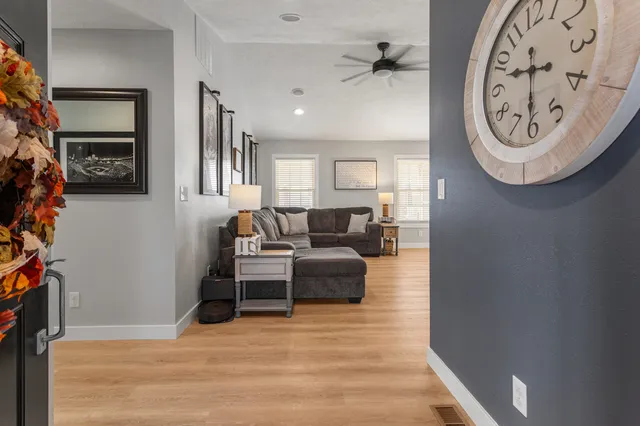 a living room with furniture a clock and a window