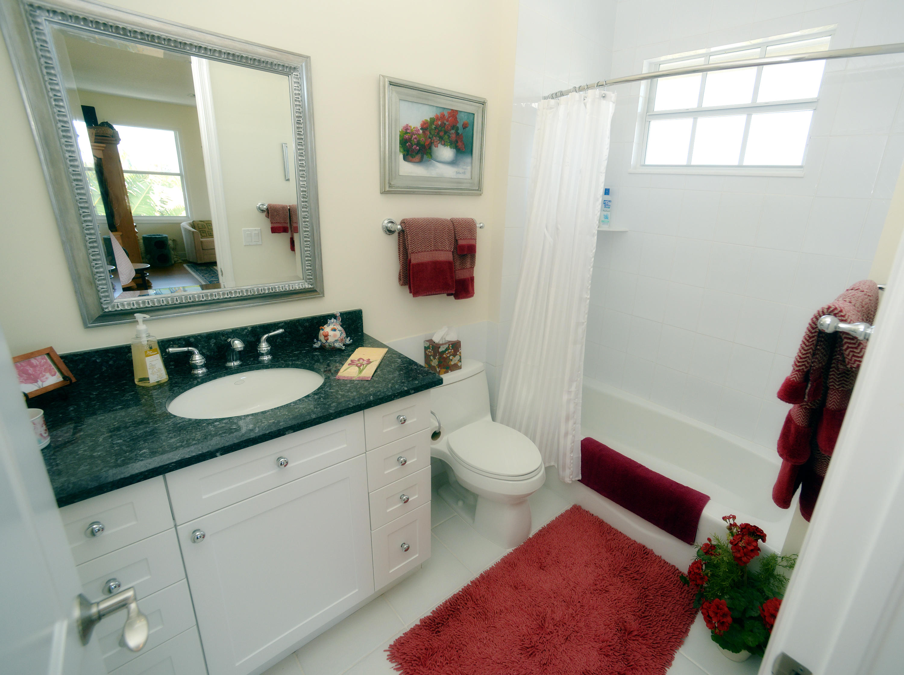 481 Olympus Drive, Unit 201 Juno Beach, FL 33408 - Photo 12 of 23 a bathroom with a granite countertop sink mirror vanity and toilet