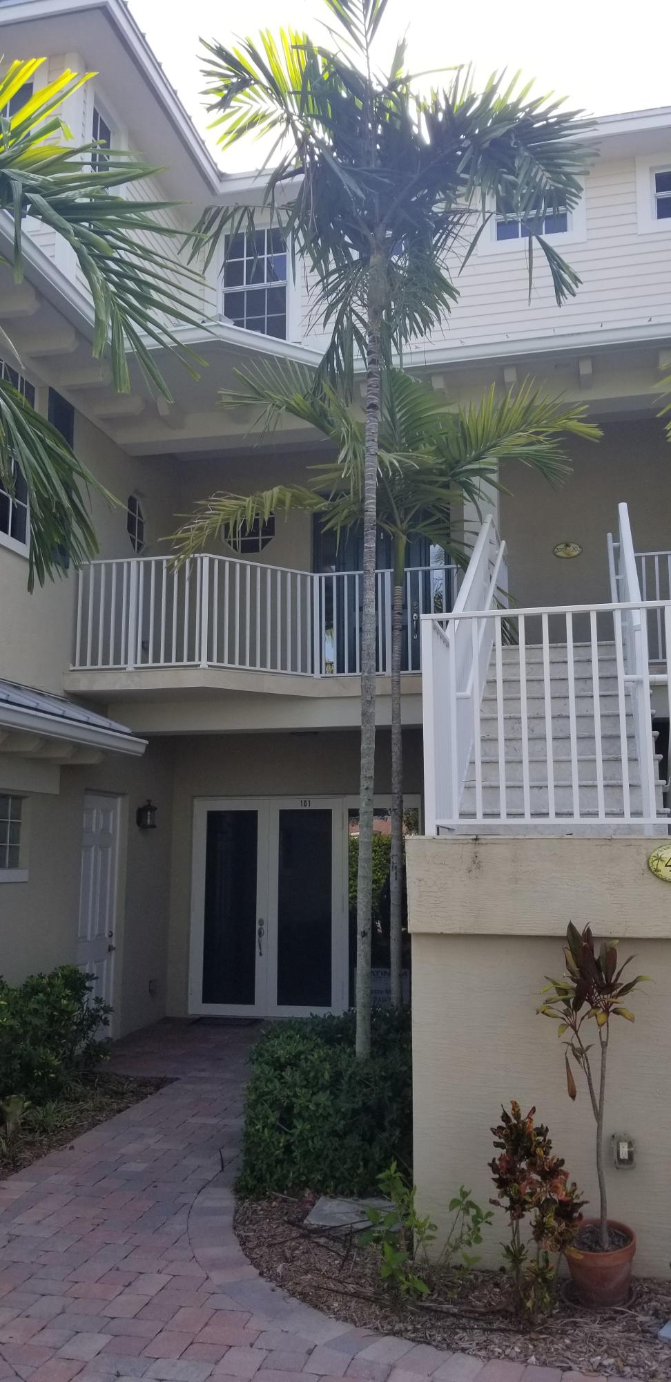 481 Olympus Drive, Unit 201 Juno Beach, FL 33408 - Photo 22 of 23 a front view of a house with a garden