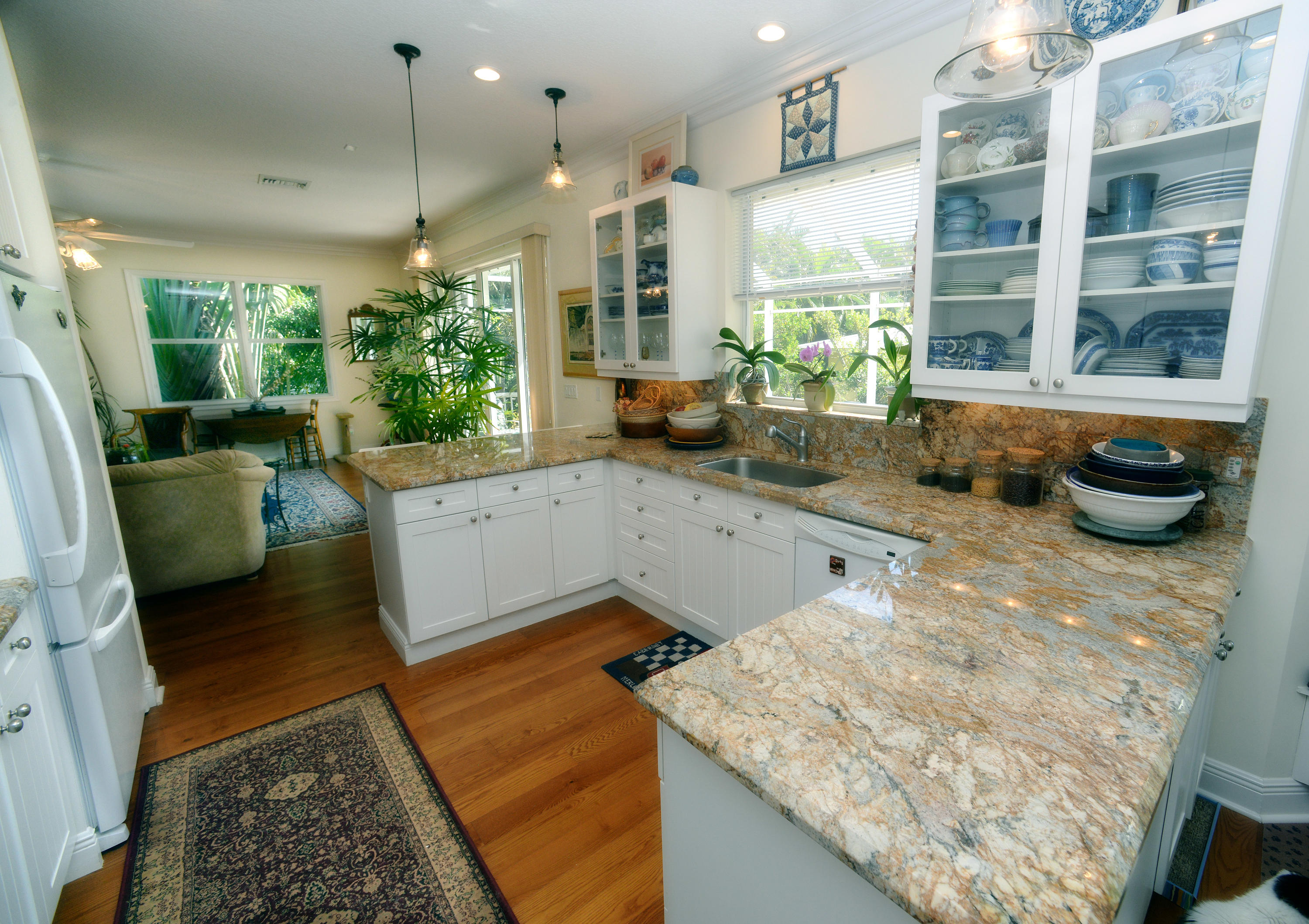 481 Olympus Drive, Unit 201 Juno Beach, FL 33408 - Photo 6 of 23 a large kitchen with kitchen island granite countertop a large window