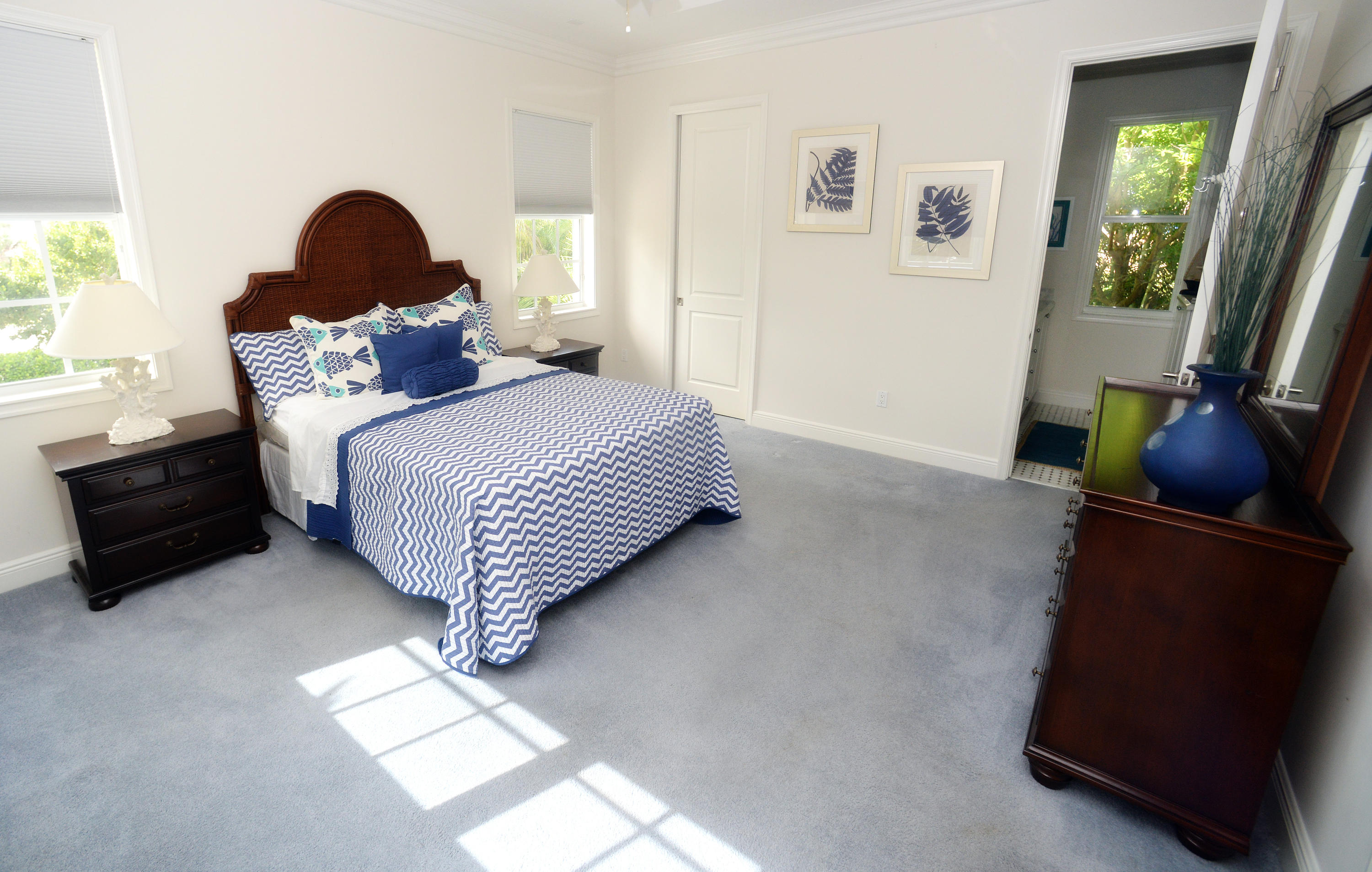 481 Olympus Drive, Unit 201 Juno Beach, FL 33408 - Photo 7 of 23 a bedroom with a bed and a painting on the wall