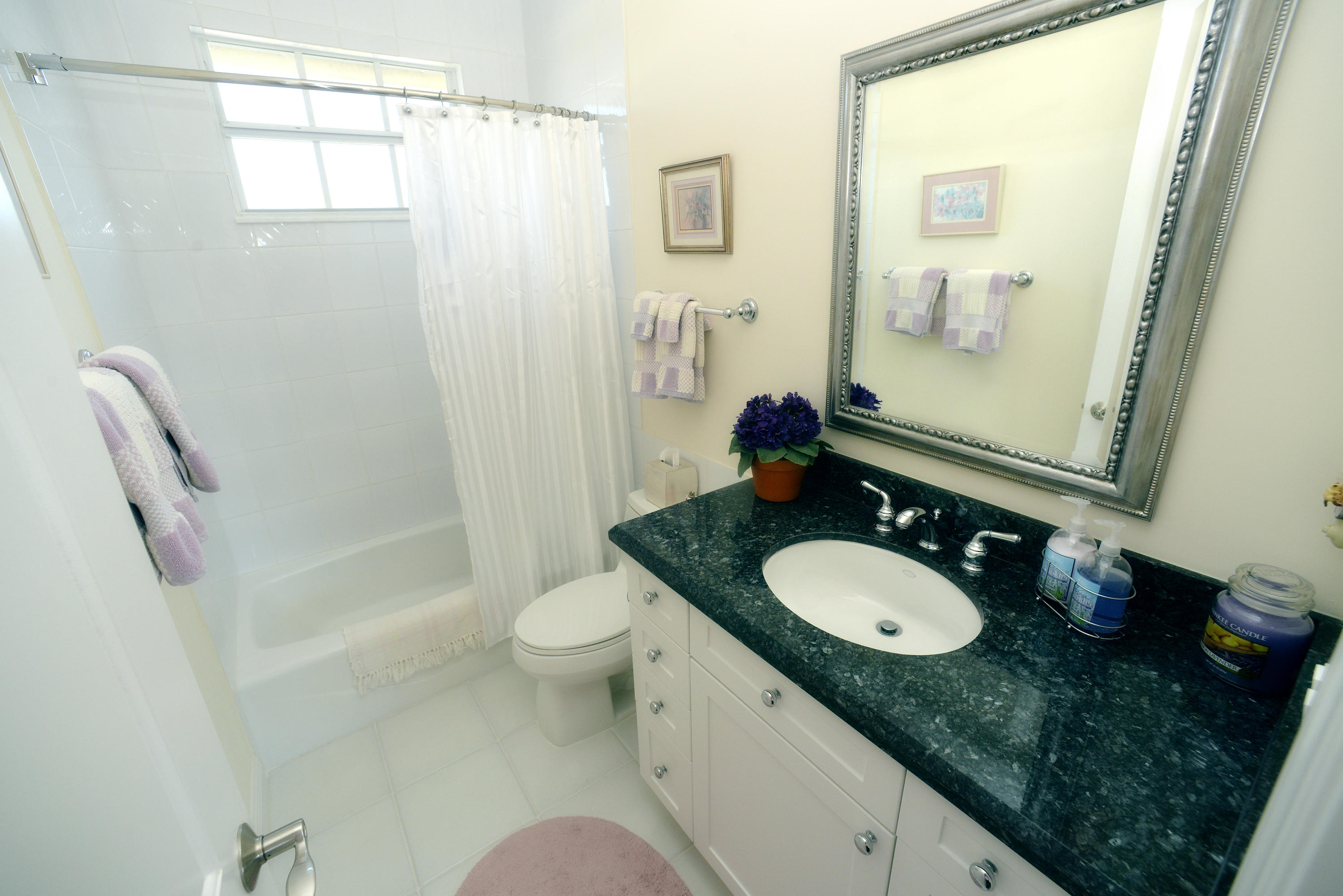 481 Olympus Drive, Unit 201 Juno Beach, FL 33408 - Photo 10 of 23 a bathroom with a granite countertop sink toilet and shower