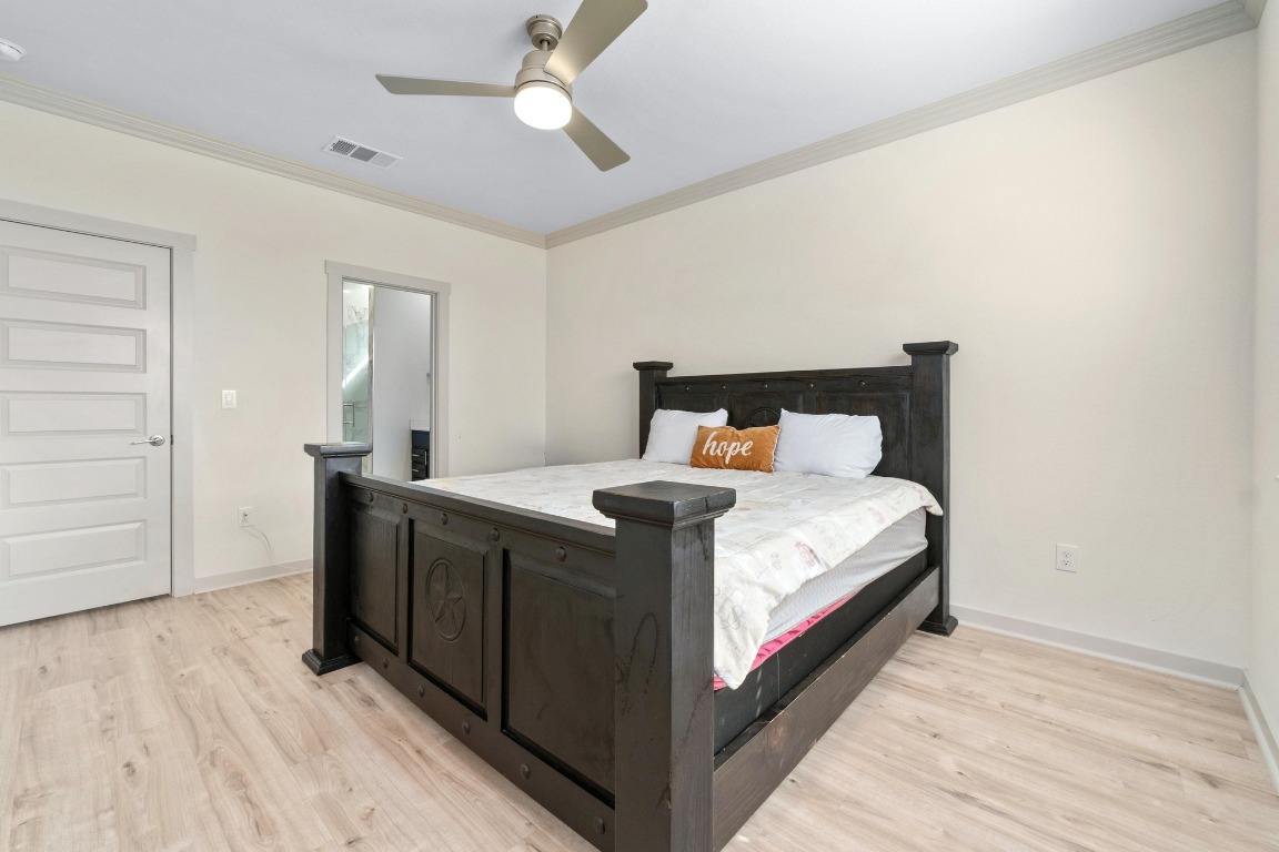 7709 Jacobean Way Austin, TX 78724 - Photo 11 of 23 a bedroom with a bed and wooden floor