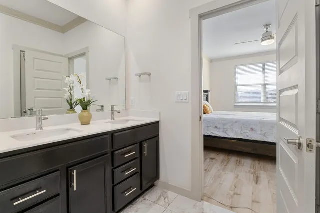 a en suite bathroom with a double vanity sink a mirror and a bathtub
