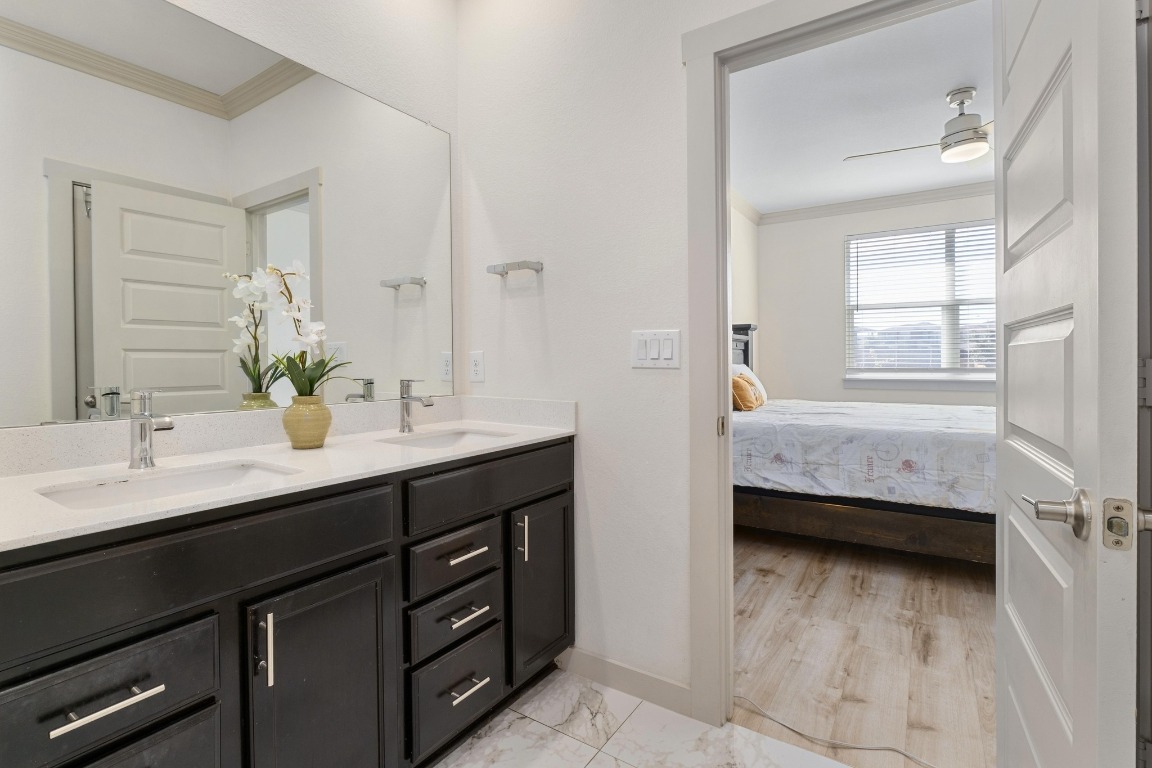 7709 Jacobean Way Austin, TX 78724 - Photo 13 of 23 a en suite bathroom with a double vanity sink a mirror and a bathtub