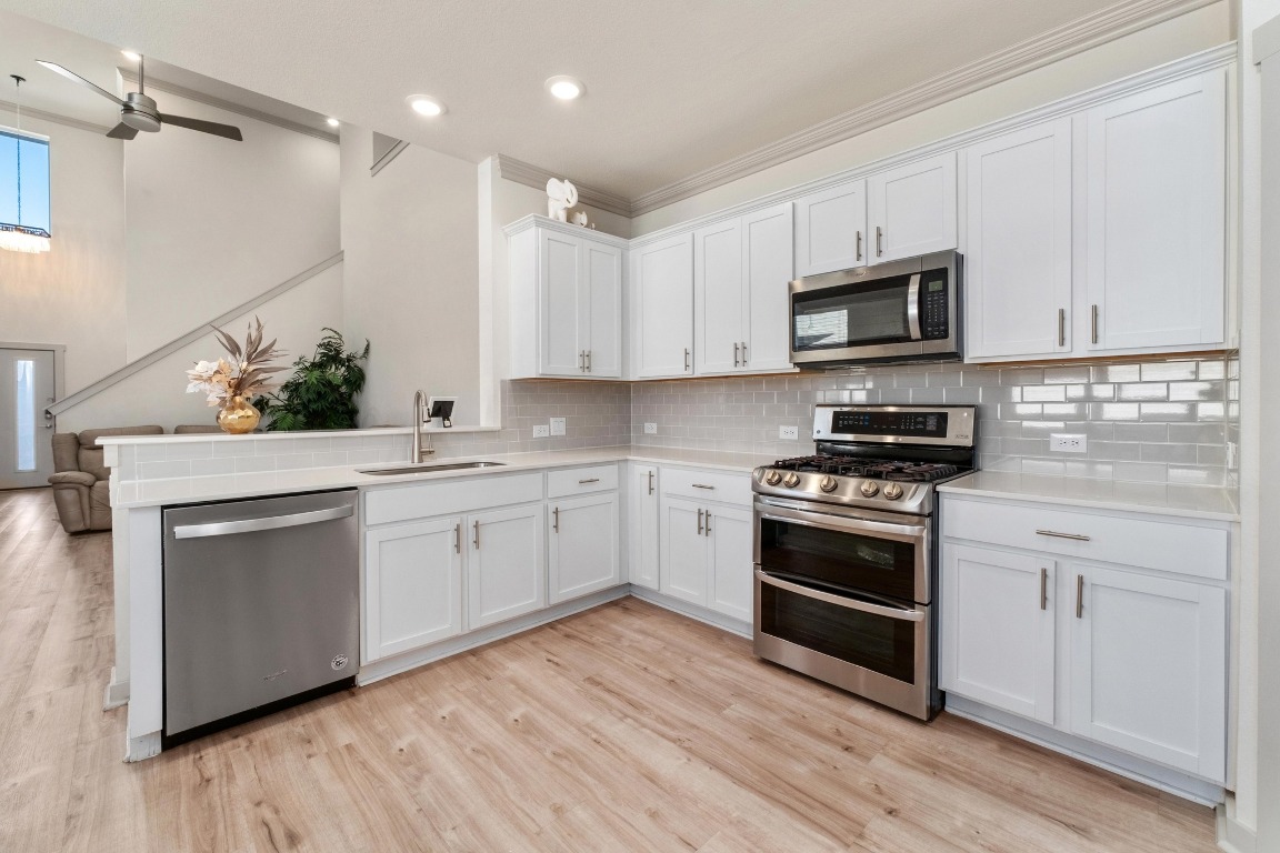 7709 Jacobean Way Austin, TX 78724 - Photo 6 of 23 a kitchen with white cabinets stainless steel appliances and sink
