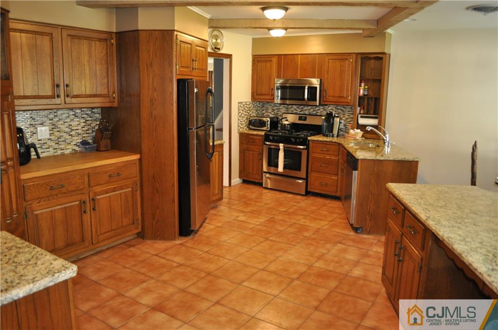 168 Colonia Road Colonia, NJ 07067 - Photo 8 of 23 a kitchen with stainless steel appliances granite countertop a refrigerator stove and sink