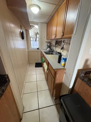 a kitchen with granite countertop stainless steel appliances a sink a stove a refrigerator and cabinets