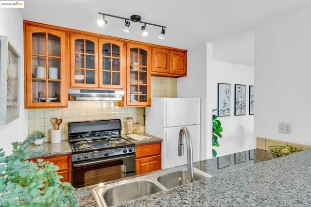a kitchen with stainless steel appliances granite countertop a refrigerator and a stove