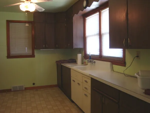 a kitchen with a sink cabinets and a window