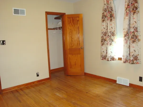 an empty room with windows and closet