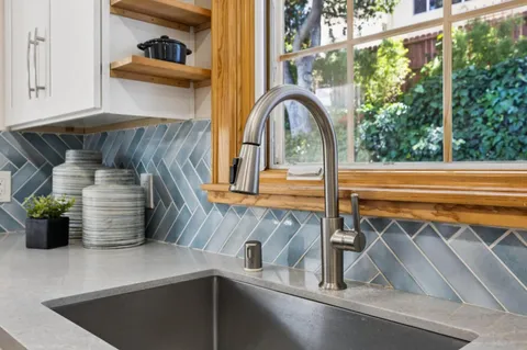 a kitchen with white cabinets and sink