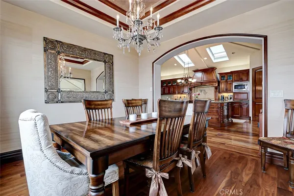 a view of a dining room with furniture a chandelier and wooden floor