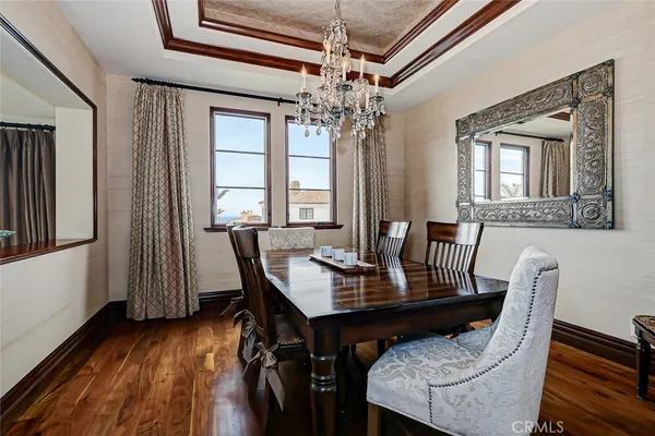 a view of a dining room with furniture a chandelier and wooden floor