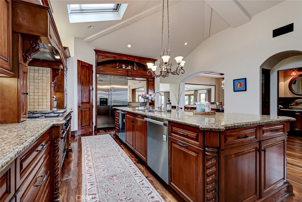 853 6th Street Manhattan Beach, CA 90266 - Photo 37 of 60 a kitchen with stainless steel appliances granite countertop a stove top oven a sink dishwasher and a dining table with wooden floor