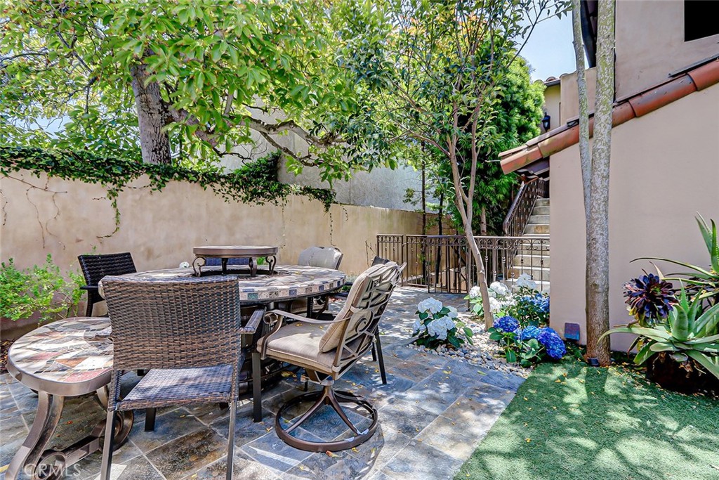 853 6th Street Manhattan Beach, CA 90266 - Photo 39 of 60 a view of a patio with table and chairs potted plants and large tree