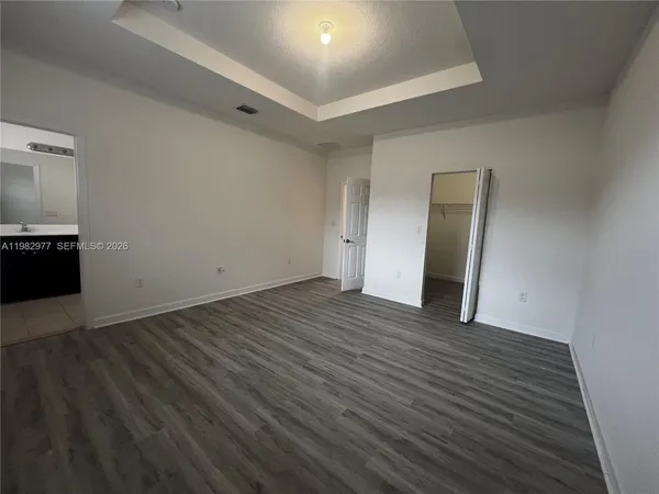 a view of an empty room with wooden floor