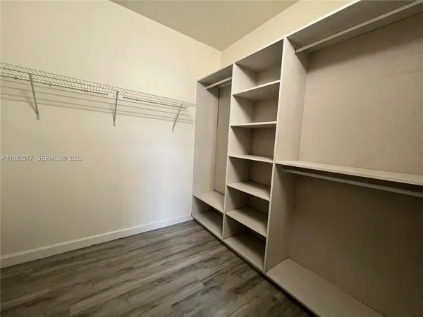 a view of walk in closet with empty racks