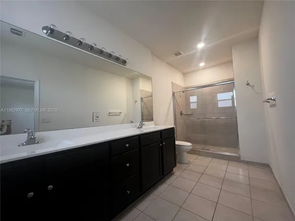 a bathroom with a double vanity sink toilet and a mirror