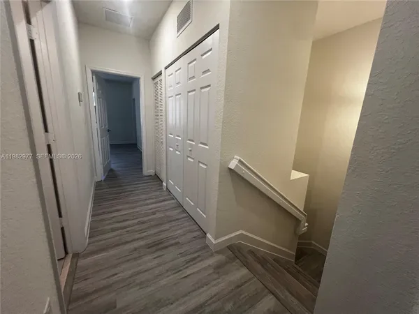 a view of a hallway with wooden floor and staircase