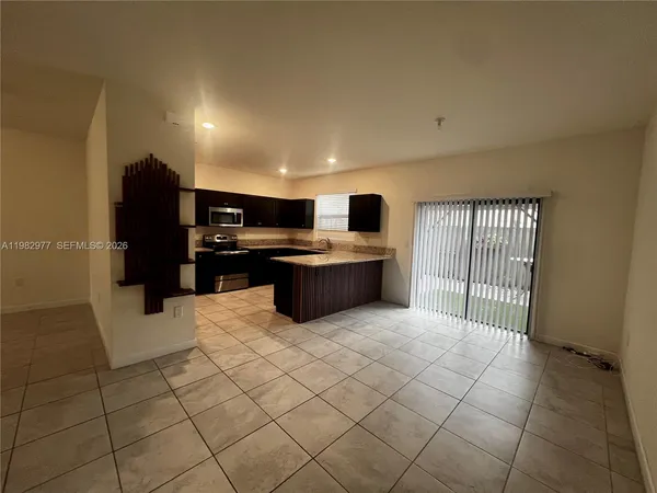 a large kitchen with stainless steel appliances granite countertop a refrigerator and a stove top oven