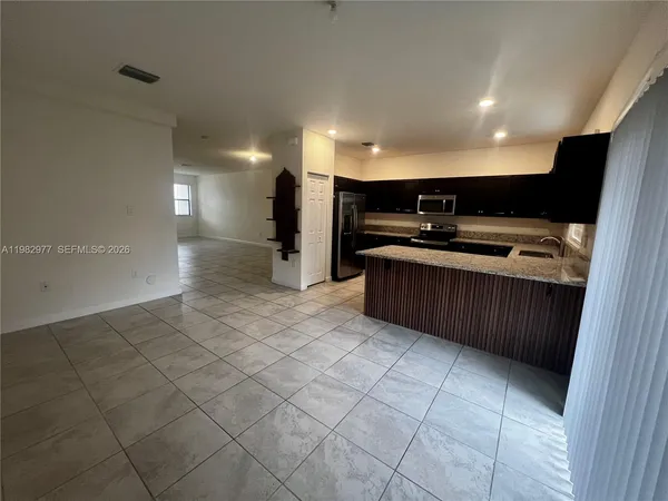 a kitchen with stainless steel appliances a sink a stove a microwave and a refrigerator