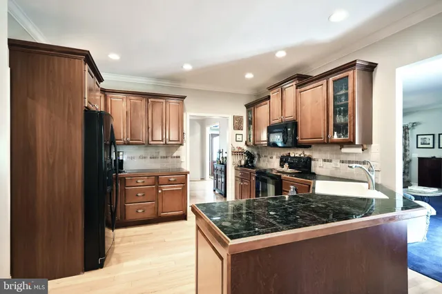 a kitchen with stainless steel appliances granite countertop a refrigerator stove top oven and sink