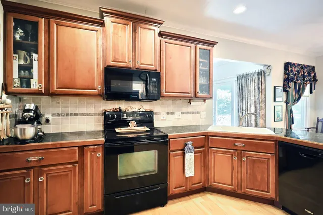 a kitchen with granite countertop a stove a sink and a microwave