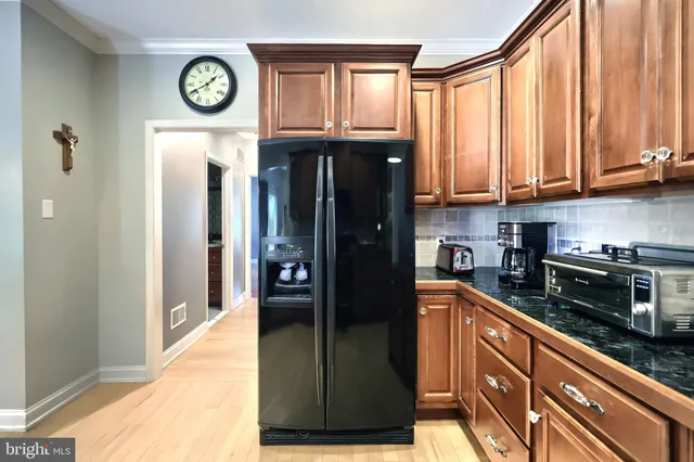 a view of a kitchen with stainless steel appliances granite countertop a refrigerator and a stove top oven