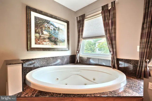 a white bath tub sitting in a bathroom next to a window