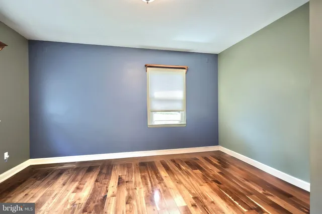 a view of a room with wooden floor and a window