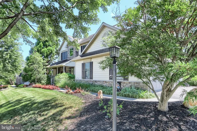 a front view of a house with a yard and an trees