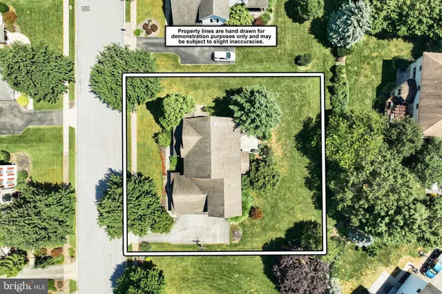 an aerial view of residential houses with outdoor space and trees