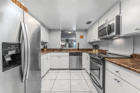 a kitchen with stainless steel appliances granite countertop a refrigerator a stove top oven a sink and dishwasher