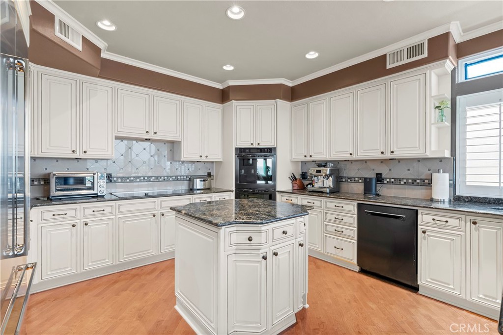 33662 Holtz Hill Drive Dana Point, CA 92629 - Photo 30 of 75 a kitchen with kitchen island granite countertop white cabinets white stainless steel appliances with a sink and dishwasher