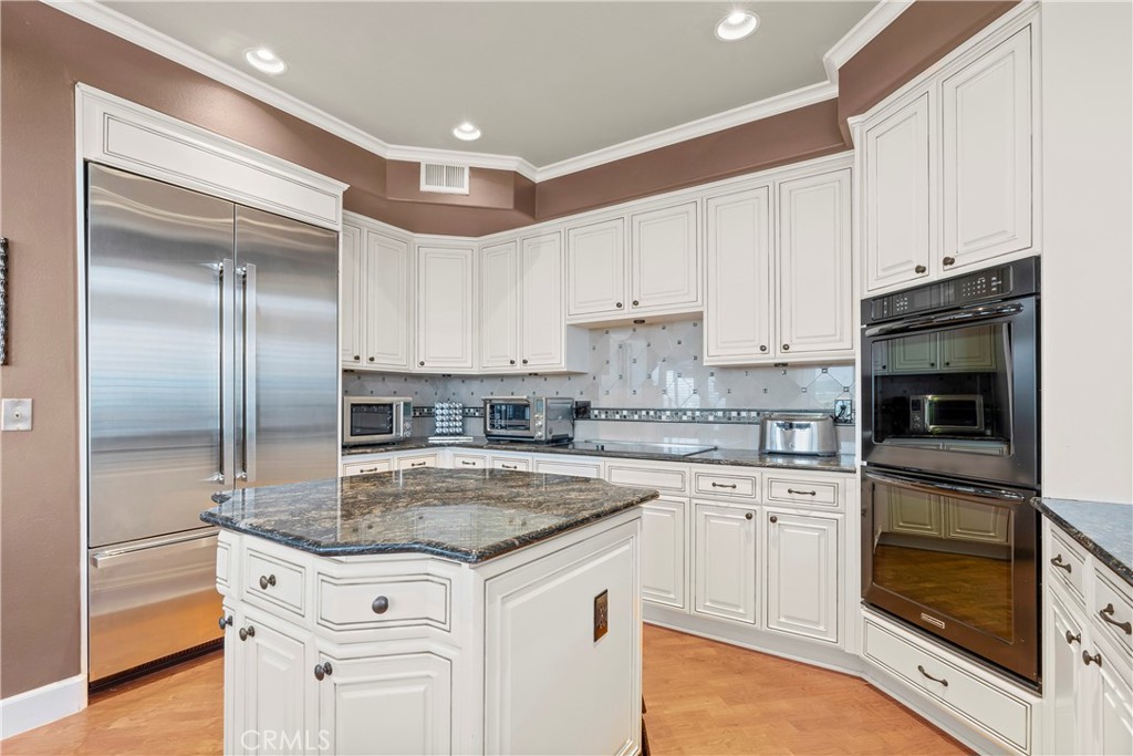 33662 Holtz Hill Drive Dana Point, CA 92629 - Photo 32 of 75 a kitchen with granite countertop a sink stainless steel appliances and white cabinets