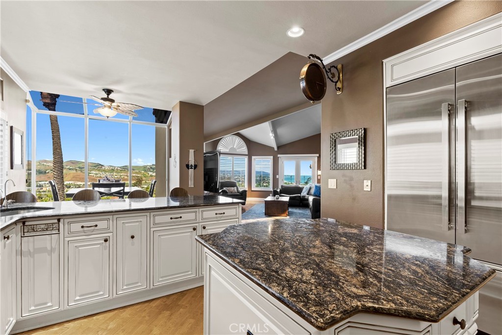 33662 Holtz Hill Drive Dana Point, CA 92629 - Photo 33 of 75 a kitchen with kitchen island granite countertop a sink counter space cabinetry and a large window