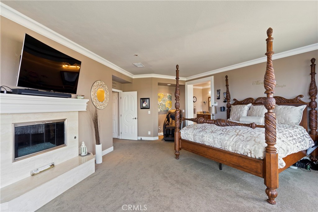 33662 Holtz Hill Drive Dana Point, CA 92629 - Photo 49 of 75 a bed room with a bed a flat screen tv and a fireplace