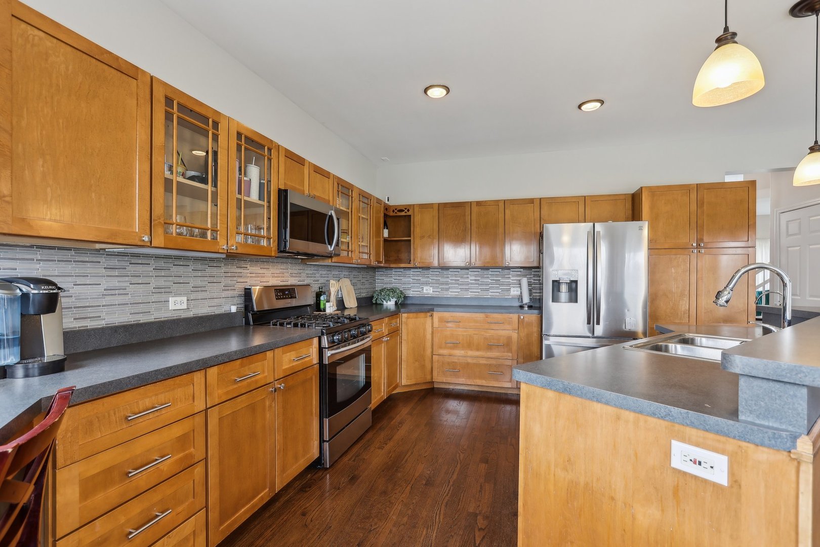 40783 Gridley Drive Antioch, IL 60002 - Photo 11 of 44 a kitchen with stainless steel appliances granite countertop wooden cabinets a stove a sink and a microwave