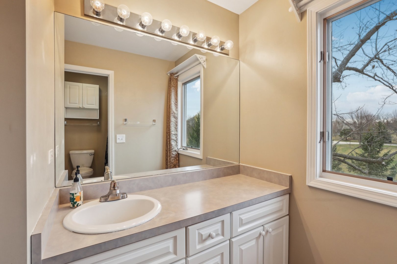40783 Gridley Drive Antioch, IL 60002 - Photo 18 of 44 a bathroom with a granite countertop sink a mirror and a shower