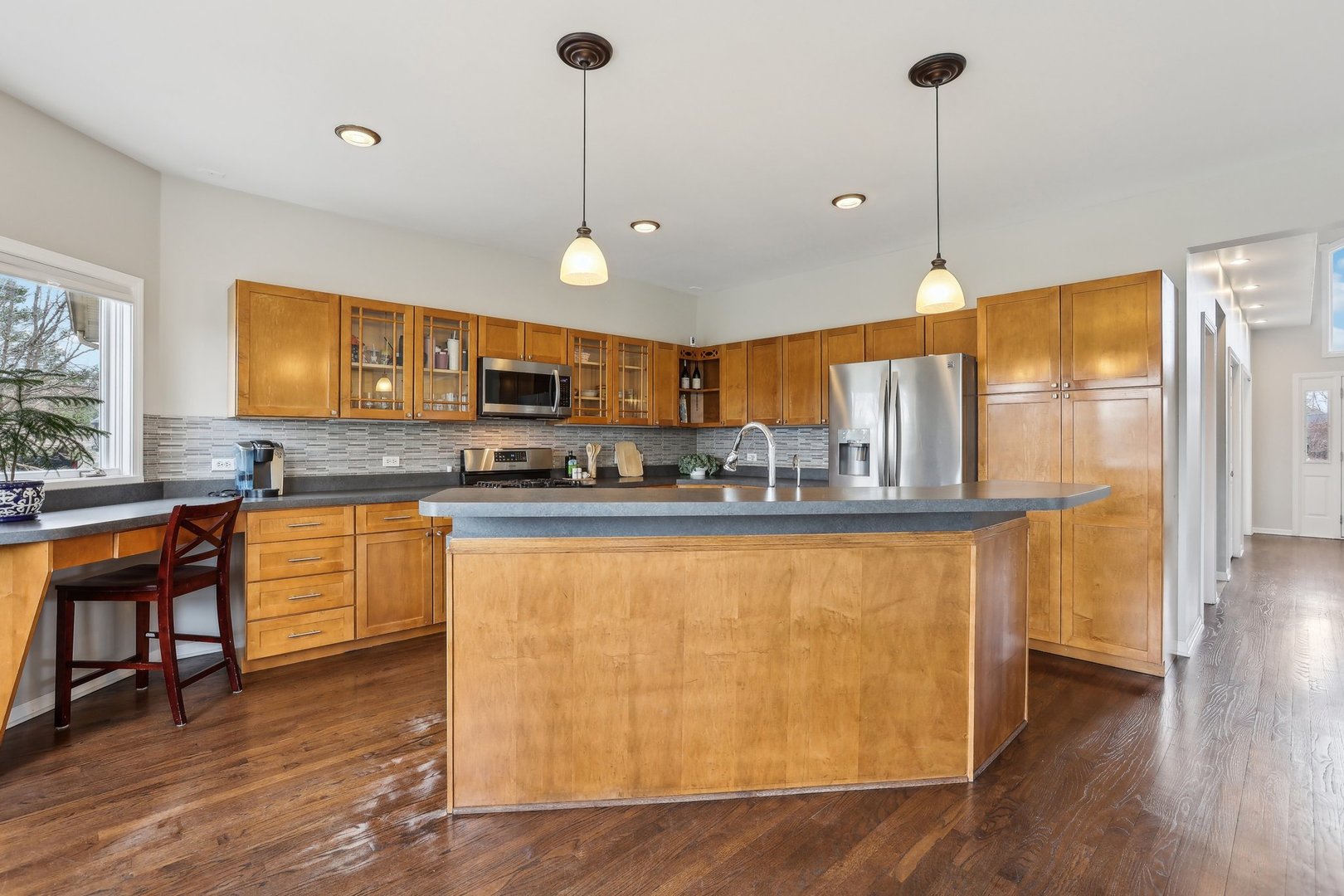40783 Gridley Drive Antioch, IL 60002 - Photo 10 of 44 a large kitchen with stainless steel appliances granite countertop a stove a sink dishwasher a microwave oven and a dining table with wooden floor