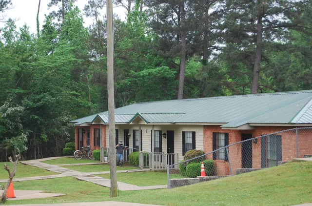 a view of a white house with a big yard and large trees