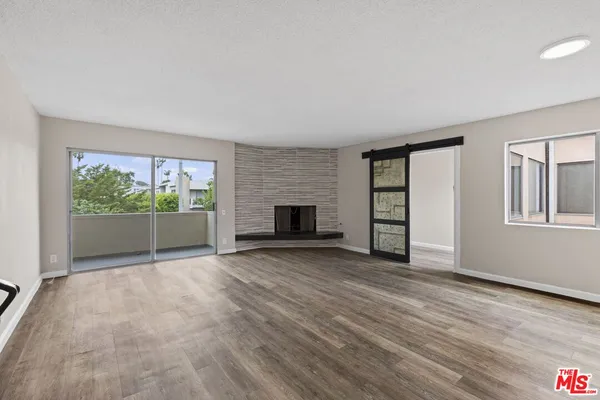 a view of empty room with wooden floor and fireplace