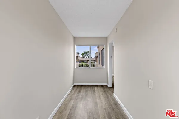 a view of a room with wooden floor and window