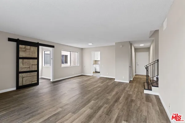 a view of empty room with wooden floor and window