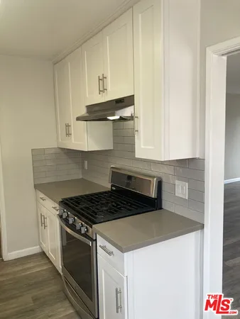 a kitchen with granite countertop white cabinets and stainless steel appliances