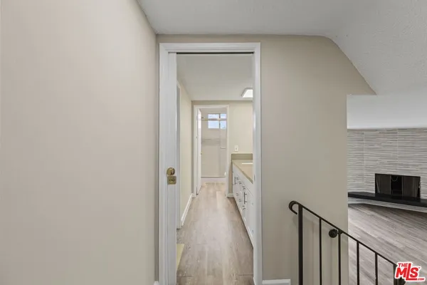 a view of a hallway with wooden floor and staircase