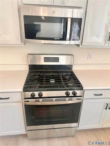 a stove top oven sitting inside of a kitchen